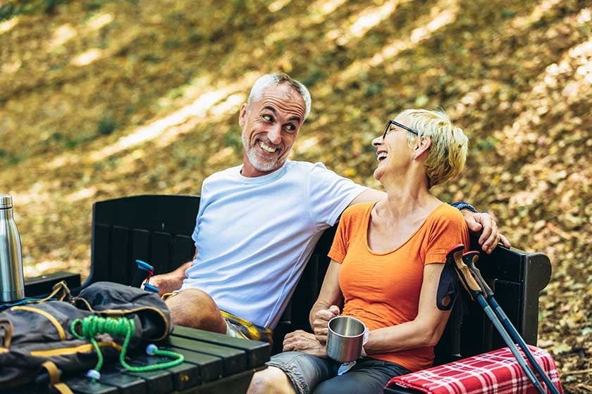 mature-couple-sitting-drink-coffee-while-resting-forest-hiking
