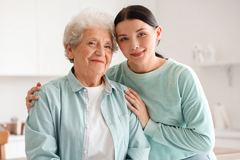 senior-woman-her-daughter-hugging-kitchen