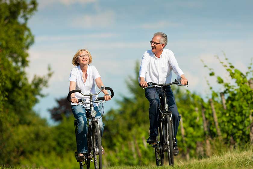 Happy couple cycling outdoors in summer