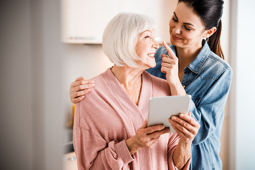 Happy grandmother and adult granddaughter having fun at home 