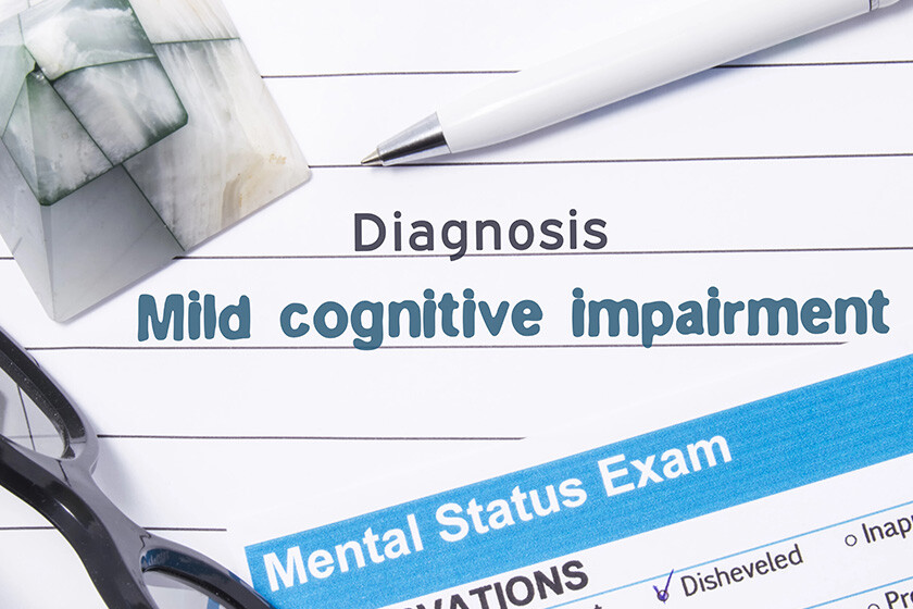 Psychiatric Diagnosis Mild Cognitive Impairment. Medical book or form with the name of diagnosis Mild Cognitive Impairment is on table of doctor surrounded by questionnaire to determine mental state