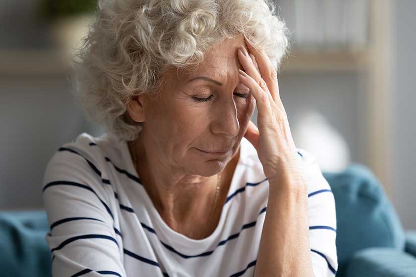 Unhealthy old mature hoary grandmother suffering from migraine.
